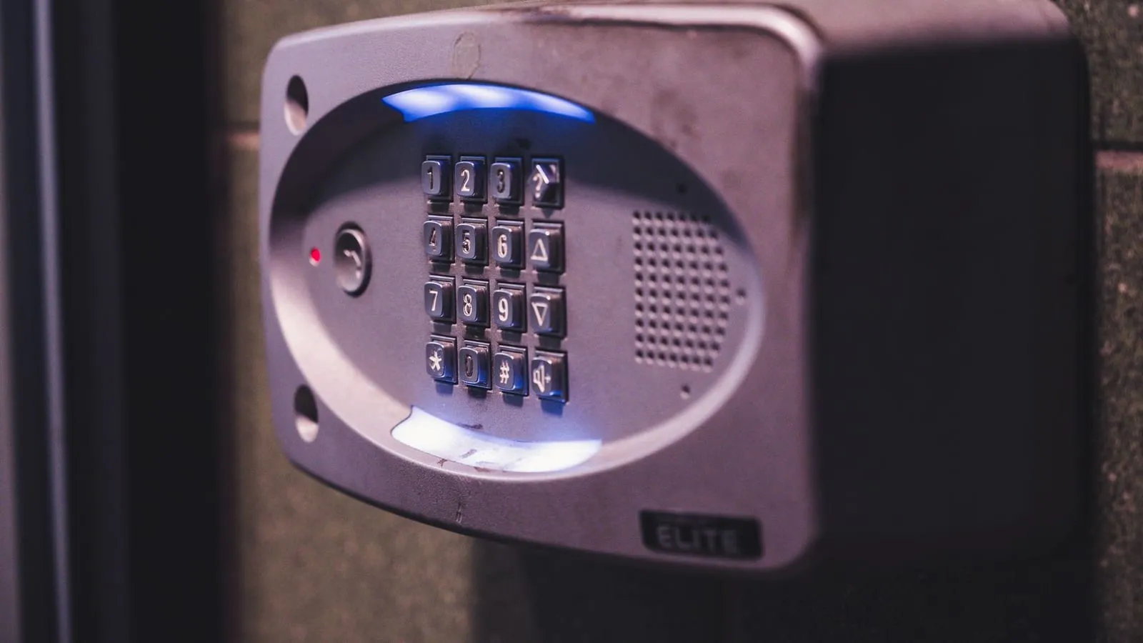 A close-up image of an illuminated security keypad mounted on a wall.
